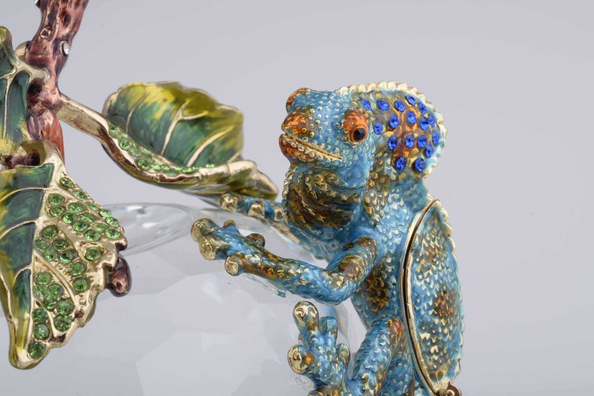 Decorative Chameleon figurine with gemstones on a gray background