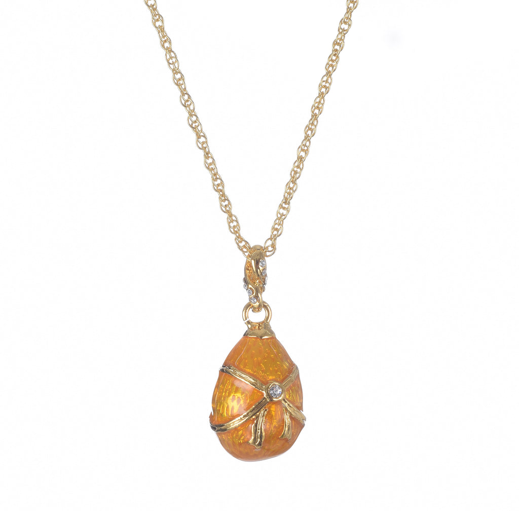 Gold necklace with an orange egg-shaped pendant on a white background