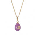 Purple teardrop pendant with gold star detail on a gold chain against a white background