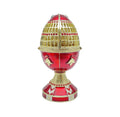 Decorative egg with gold and red design on a white background