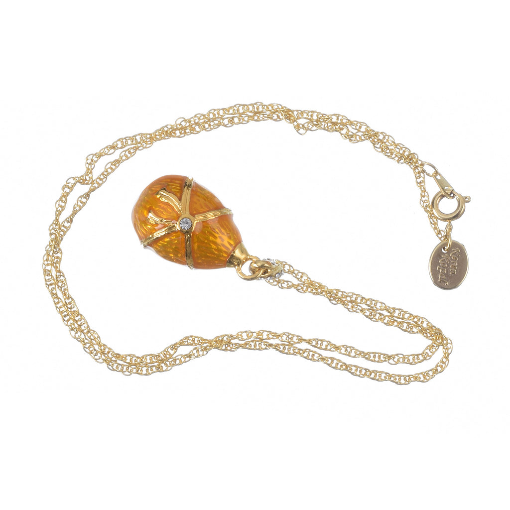 Gold necklace with a decorative egg pendant on a white background