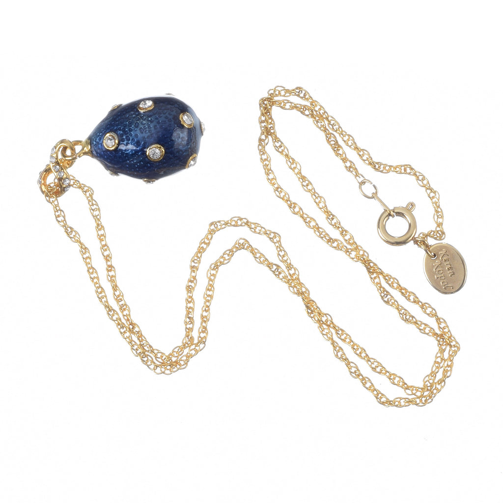Gold necklace with a blue pendant on a white background