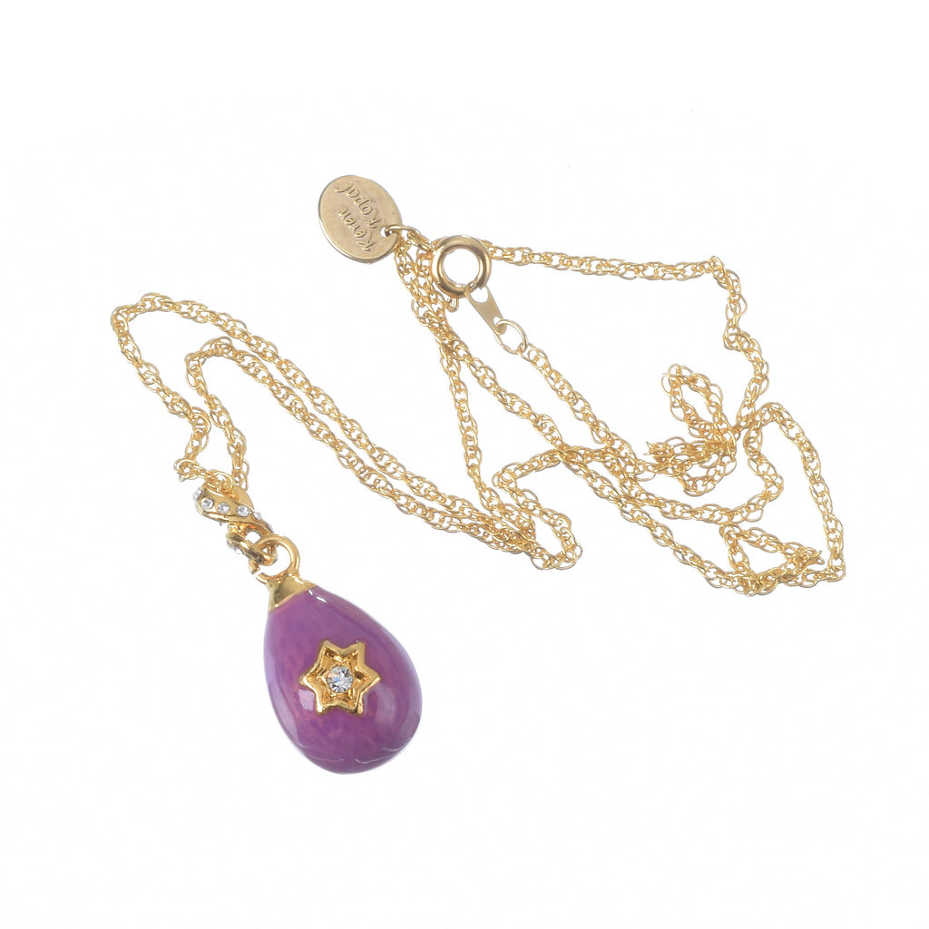 Gold necklace with a purple teardrop pendant on a white background