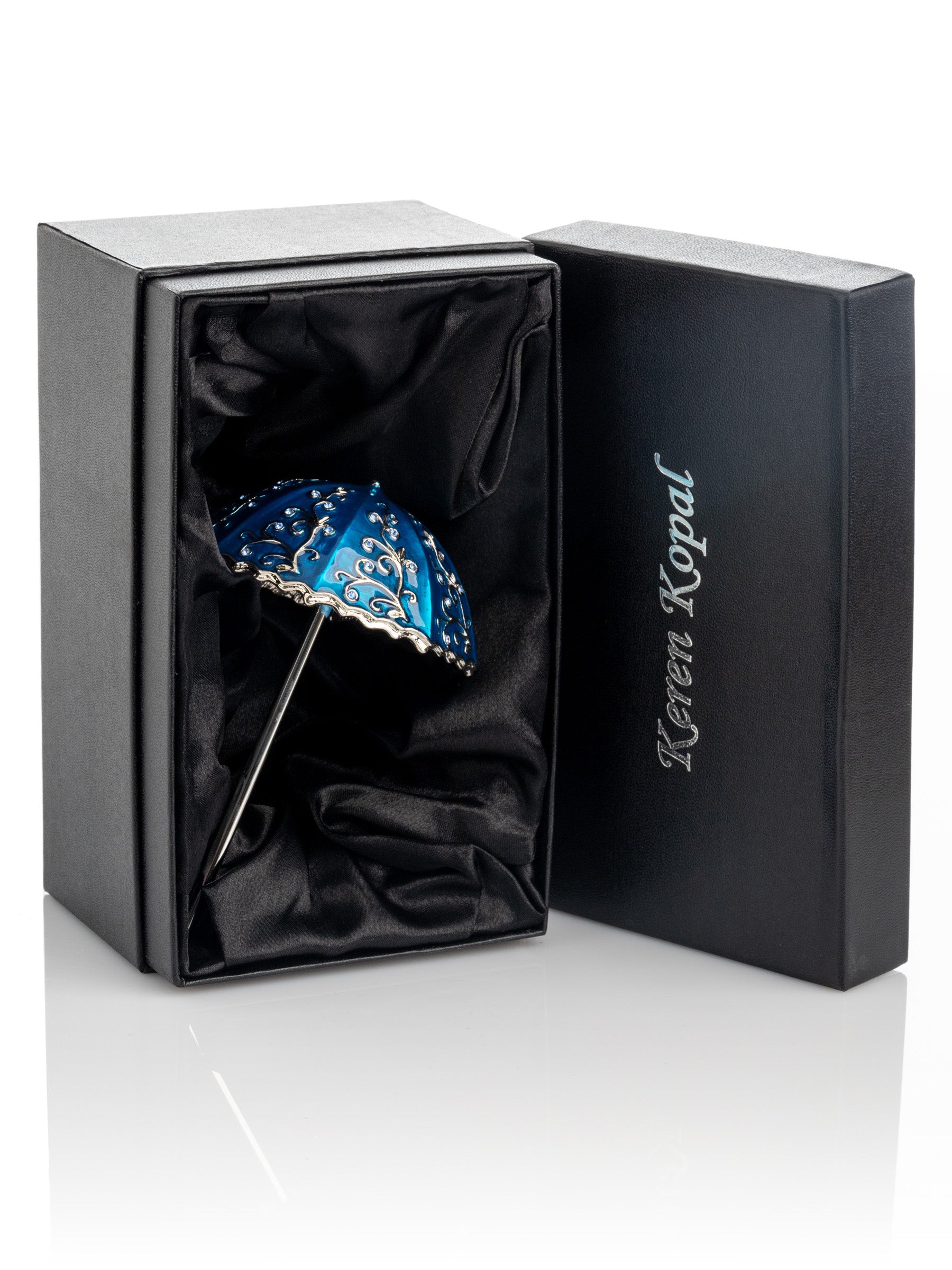 Blue decorative item in a black box with 'Keren Kopal' branding on a white background