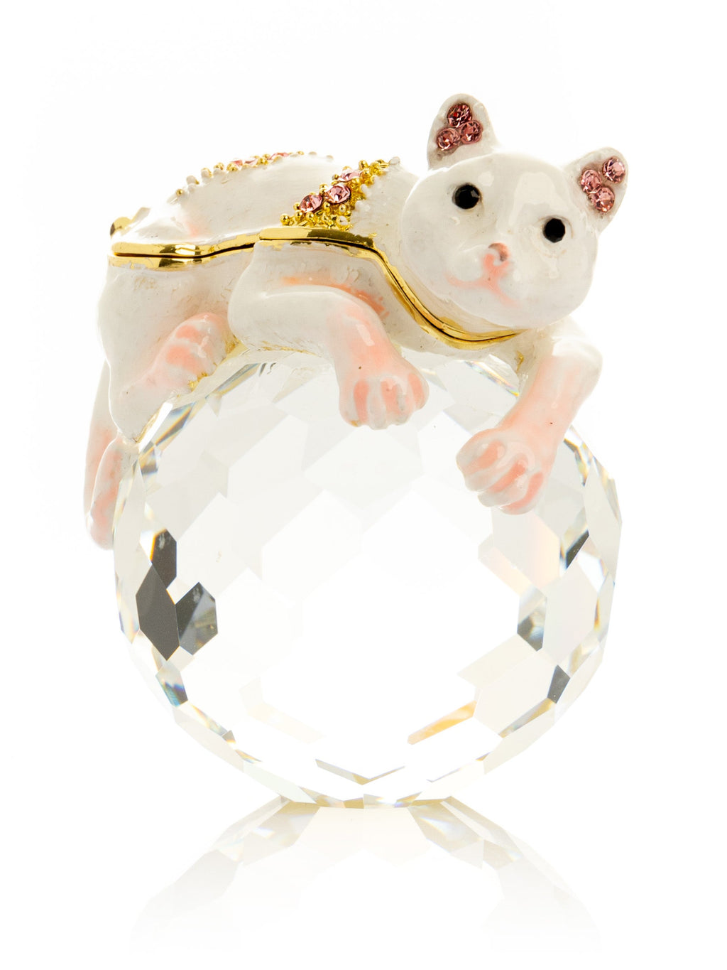 White cat figurine on crystal ball with gold accents and gemstones on white background