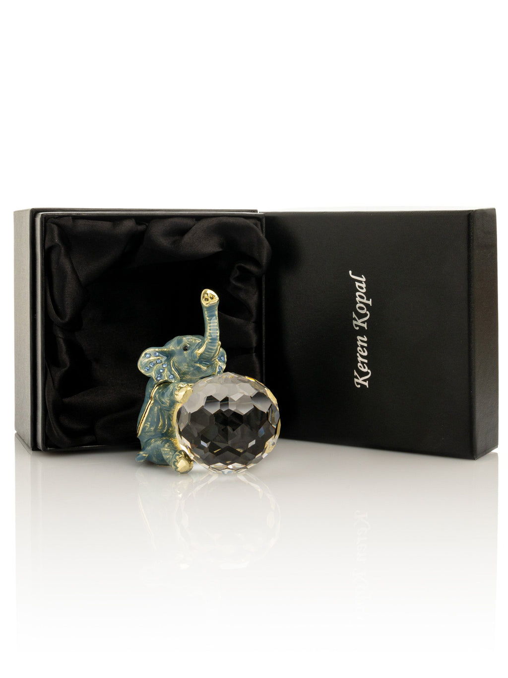 Decorative elephant figurine with crystal ball in a branded box on a white background