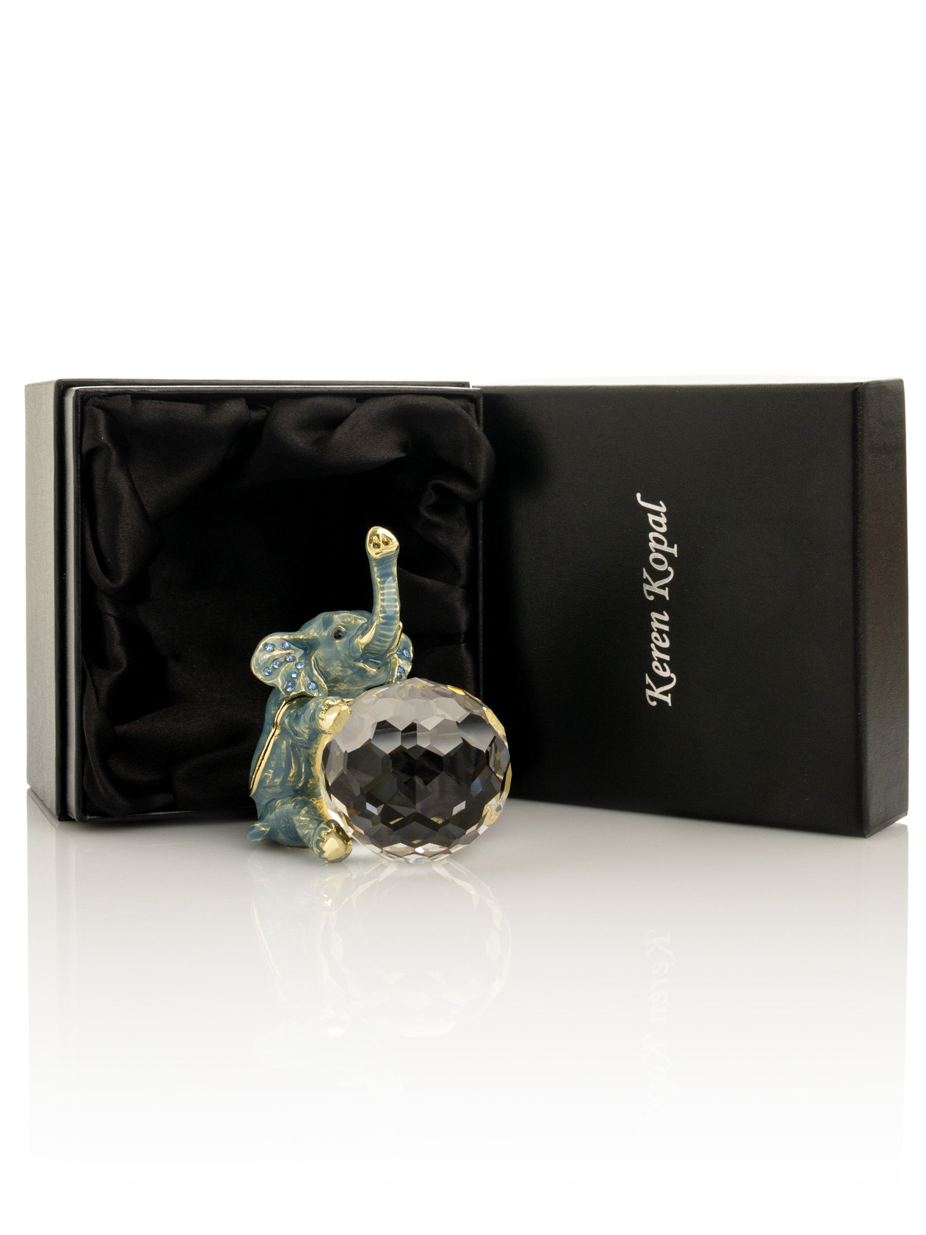 Decorative elephant figurine with crystal ball in a branded box on a white background