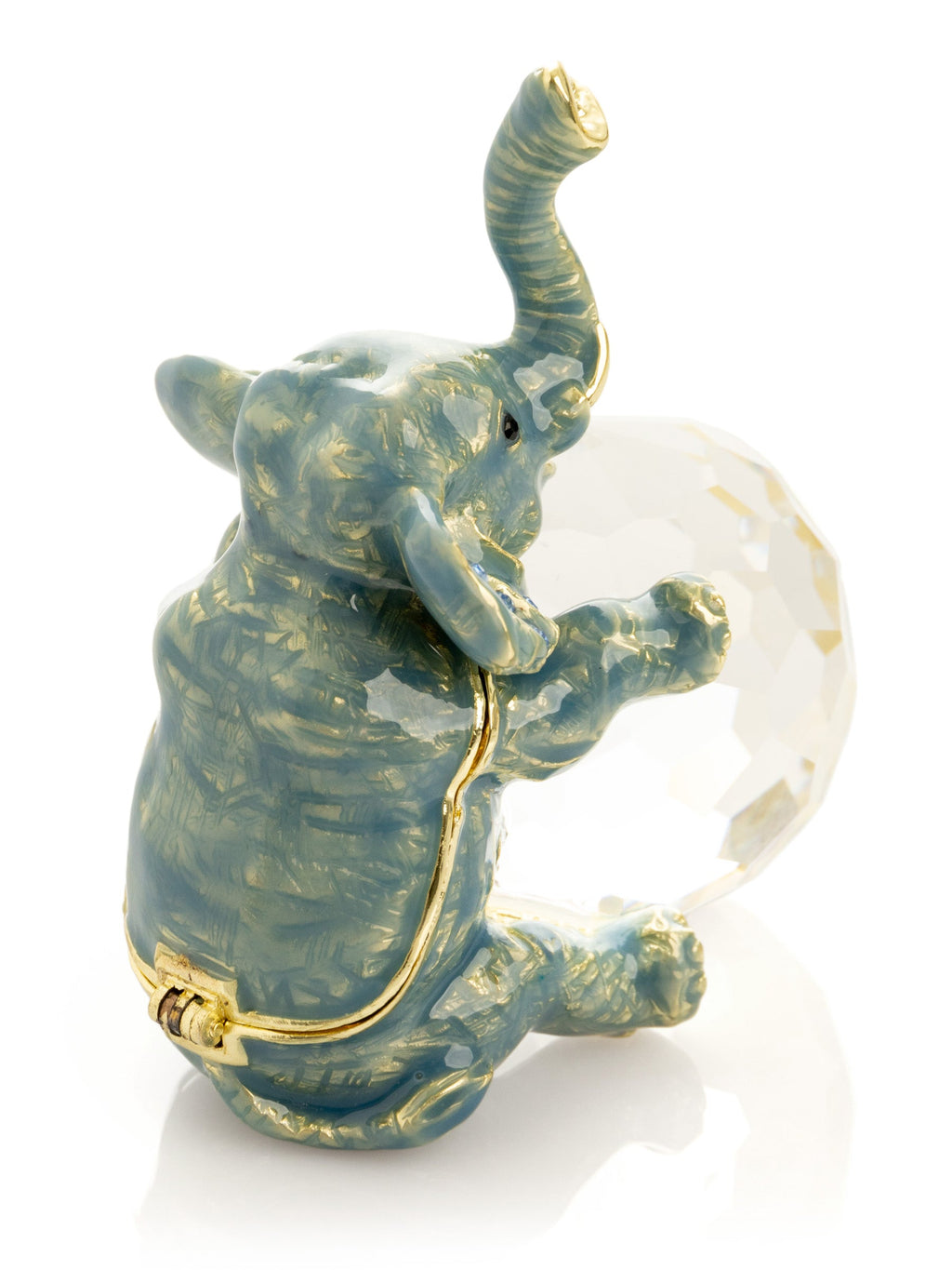 Decorative elephant figurine with a gold trunk and base, holding a crystal ball on a white background