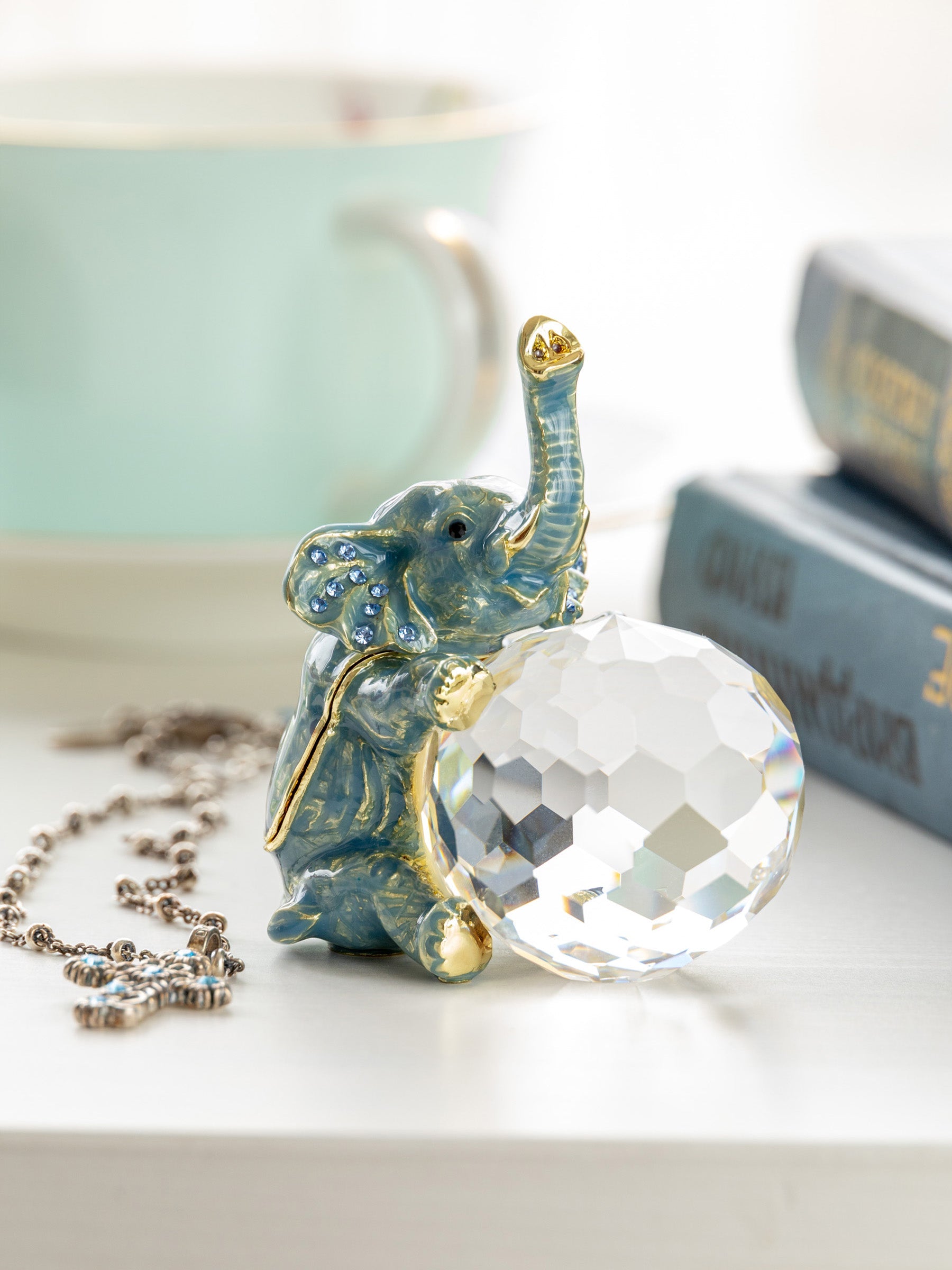 Elephant-shaped pendant with a large crystal on a white surface
