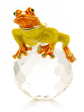 Decorative frog figurine on a crystal base with green accents