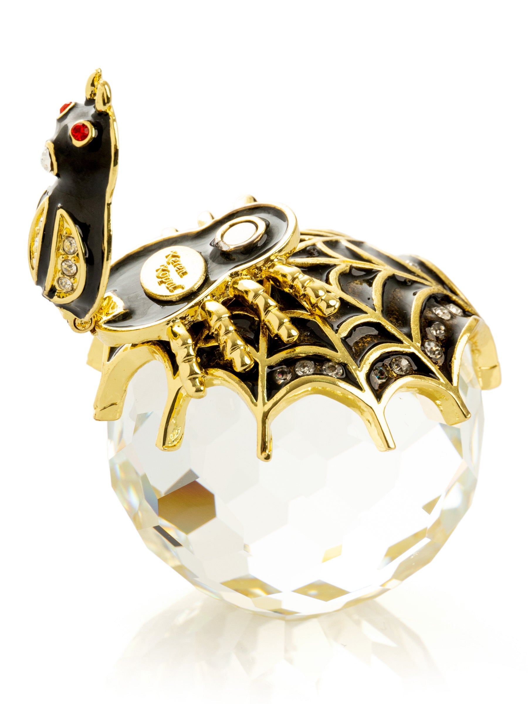 Gold and black decorative item with spider design on a white background