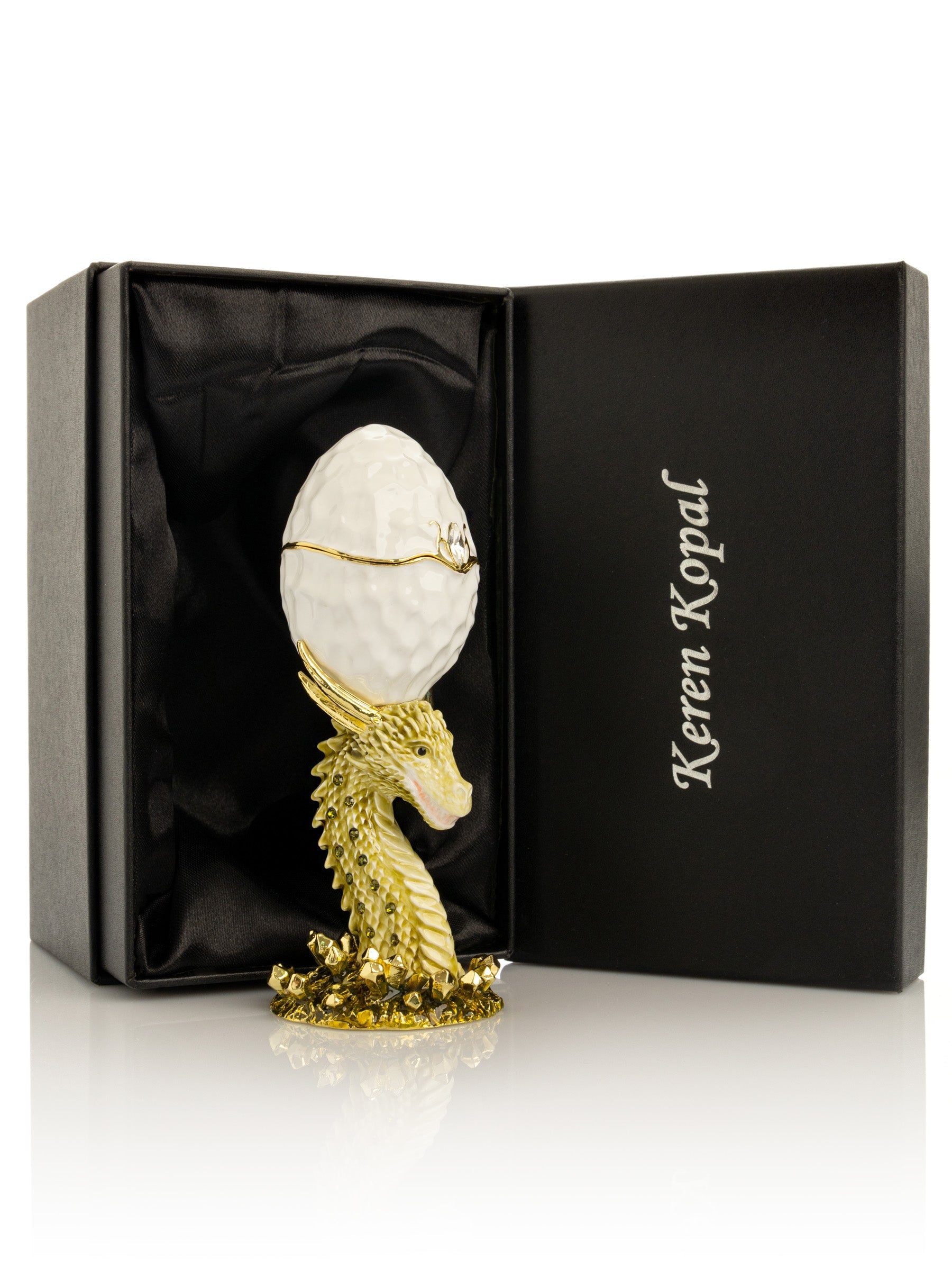 Decorative egg with gold dragon design in a Keren Kopal box on a white background