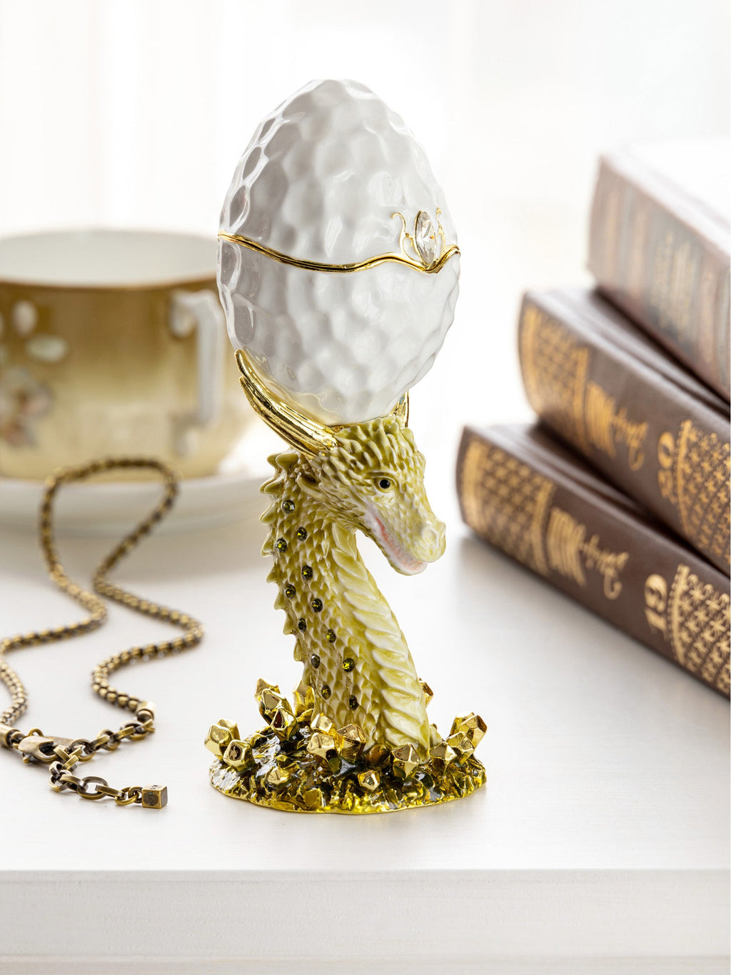 Decorative object with gold dragon and white egg on a light background