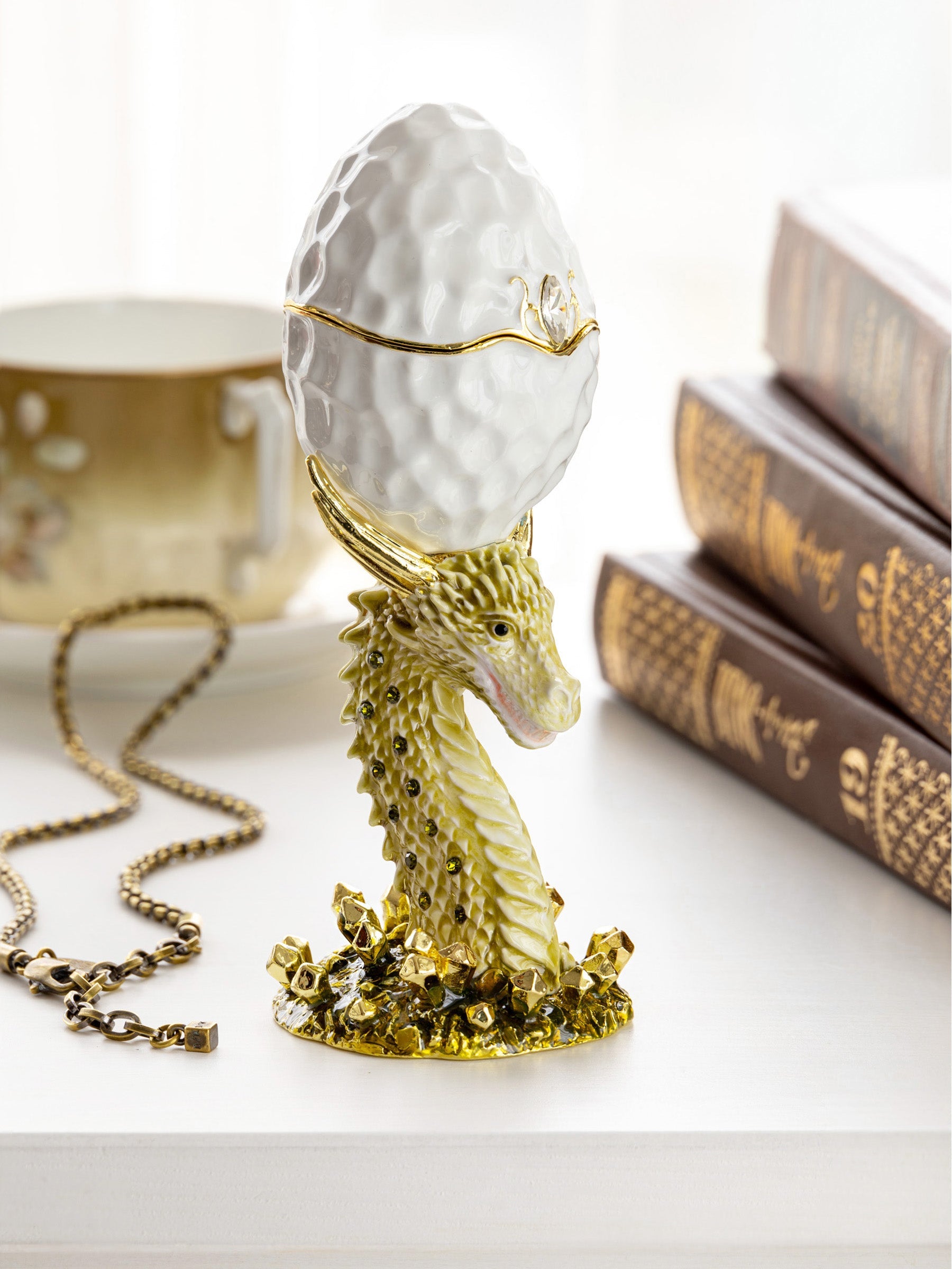 Decorative object with gold dragon and white egg on a light background