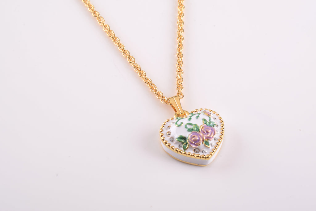 Heart-shaped floral pendant on a gold chain against a white background