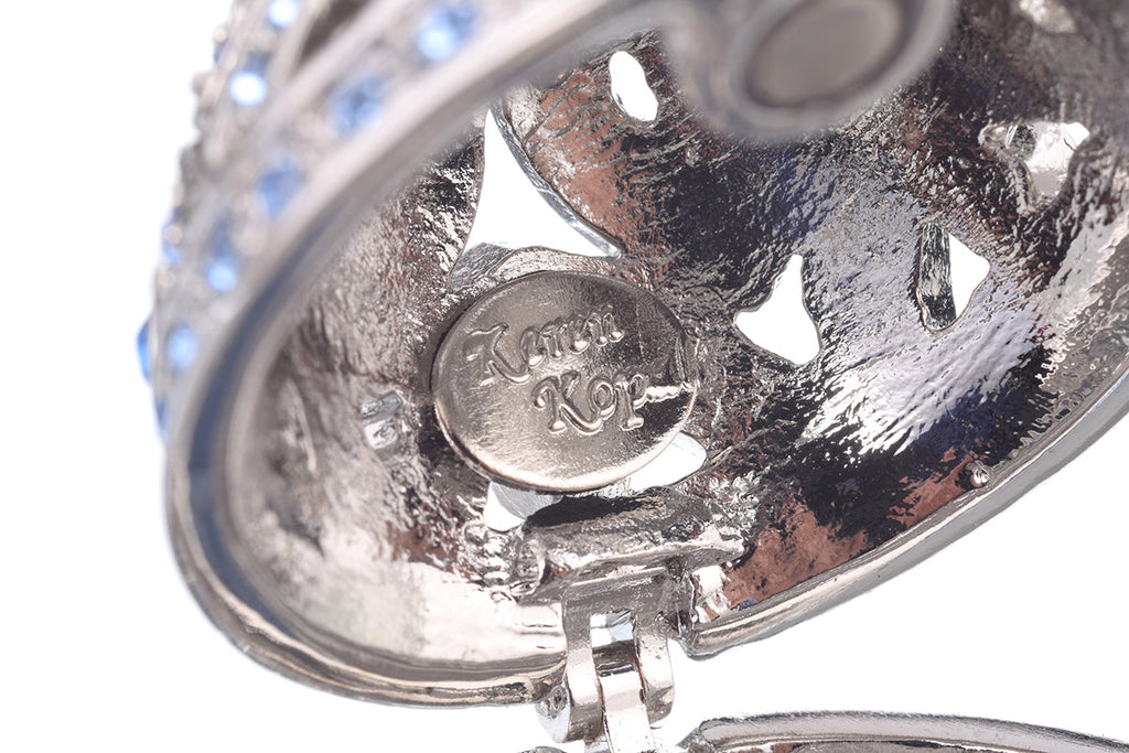 Close-up of silver Fabergé egg base with 'Keren Kopal' engraving on white background