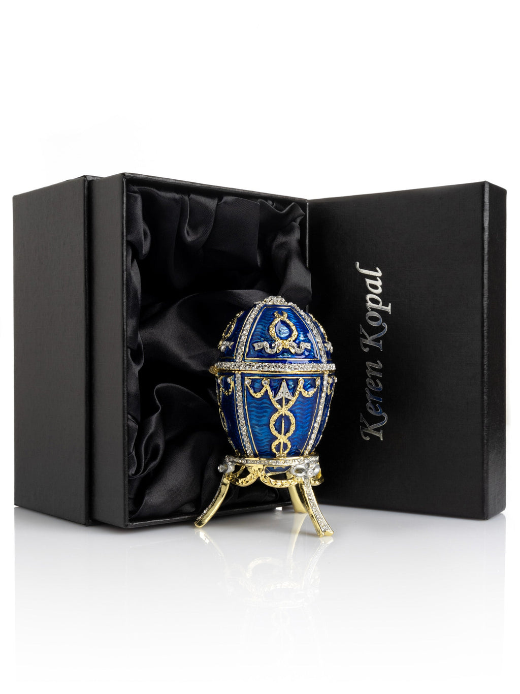Decorative egg with gold accents in a black satin-lined box, featuring the brand 'Karen Kopal'.