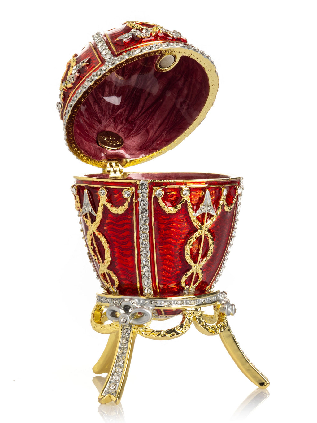 Decorative red egg with gold and silver embellishments on a white background