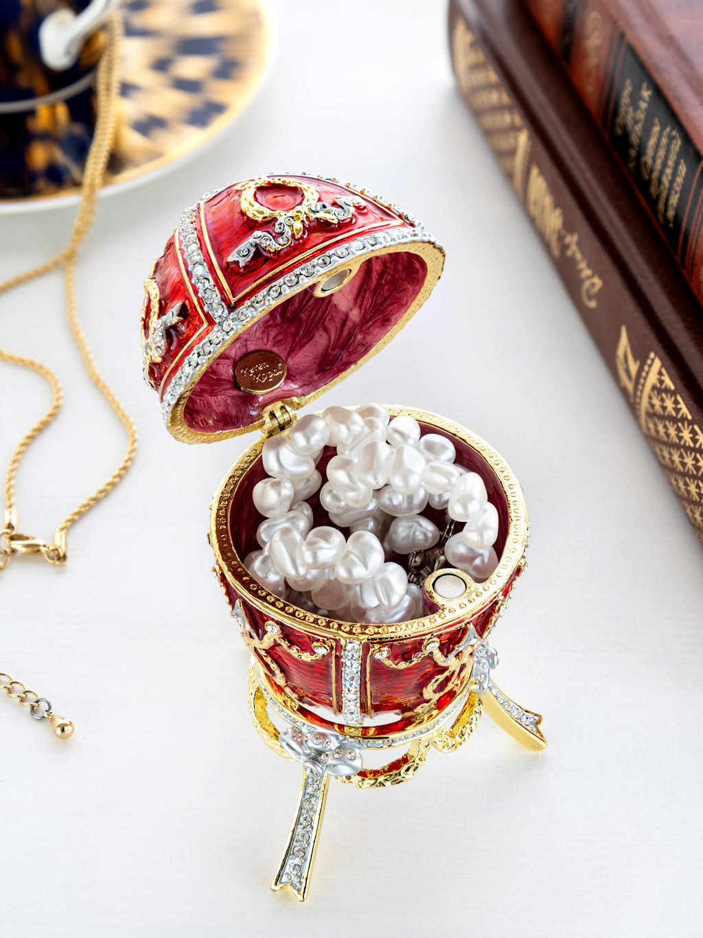 Decorative red egg with pearls on a white surface
