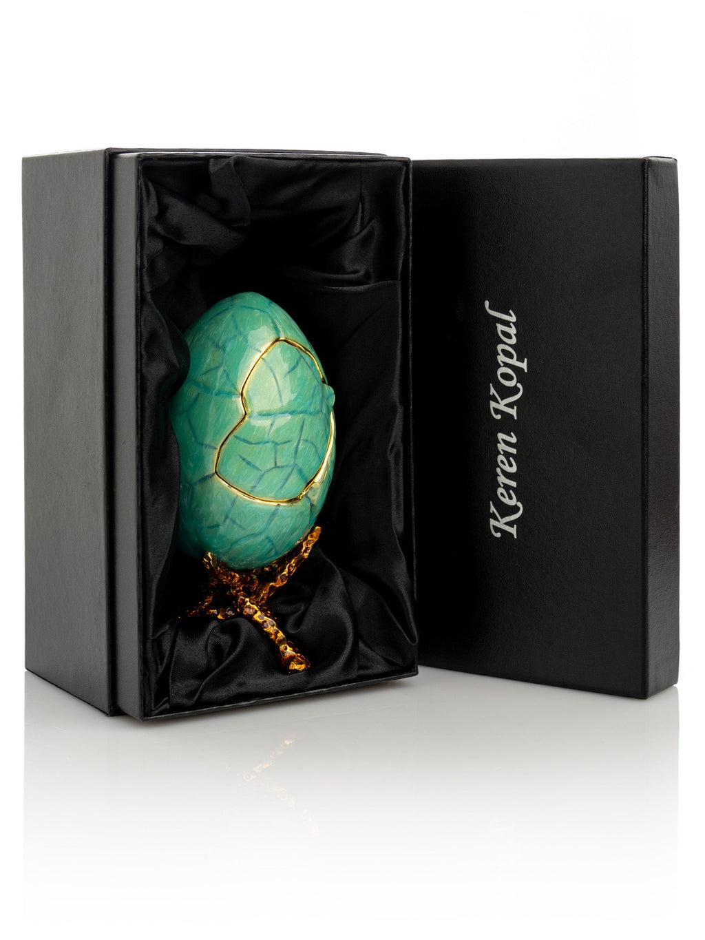 Turquoise decorative egg with gold accents in a black box, Keren Kopal brand visible
