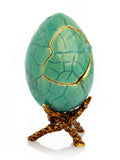 Decorative green egg with gold accents on a white background
