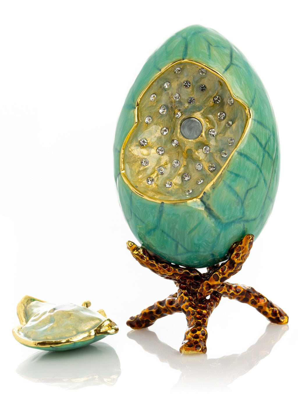 Decorative egg with gold accents and a starfish base on a white background
