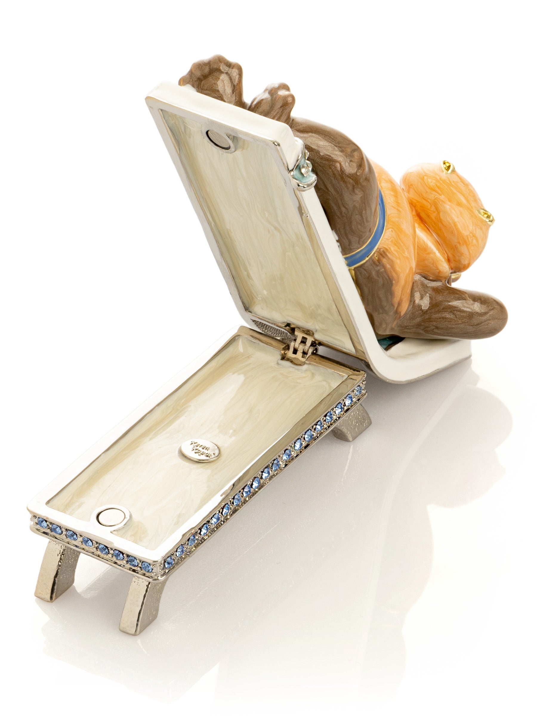 Hippo figurine lying on a bed with a phone on a white background