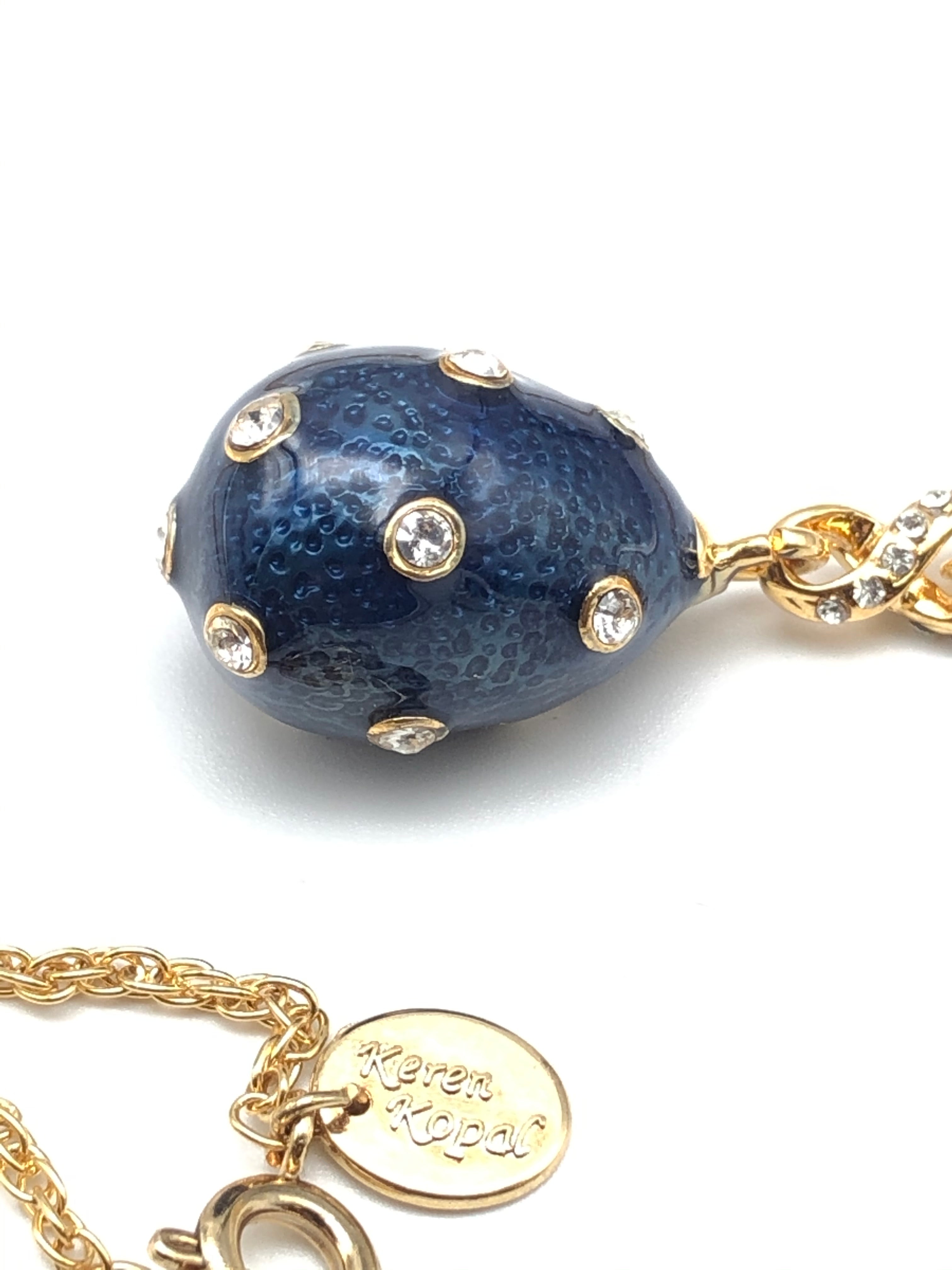 Gold bracelet with a blue bead and clear stones on a white background