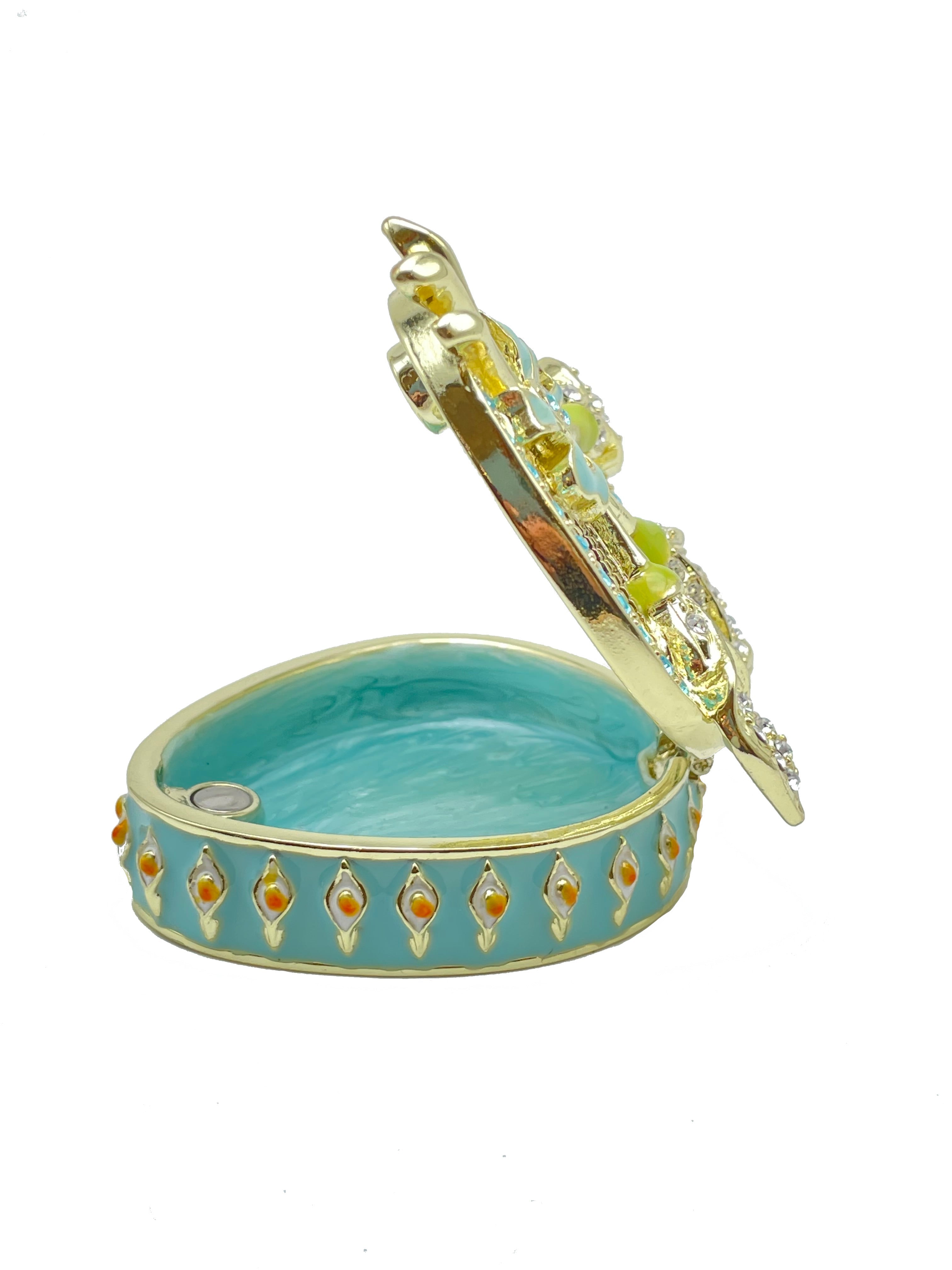 Decorative heart-shaped jewelry box with gold accents and turquoise interior on a white background