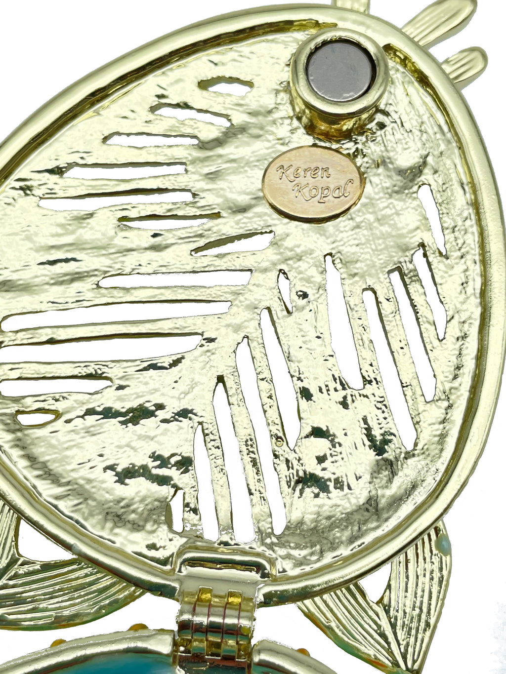 Gold locket with leaf design and 'Keren Kopal' branding on a white background