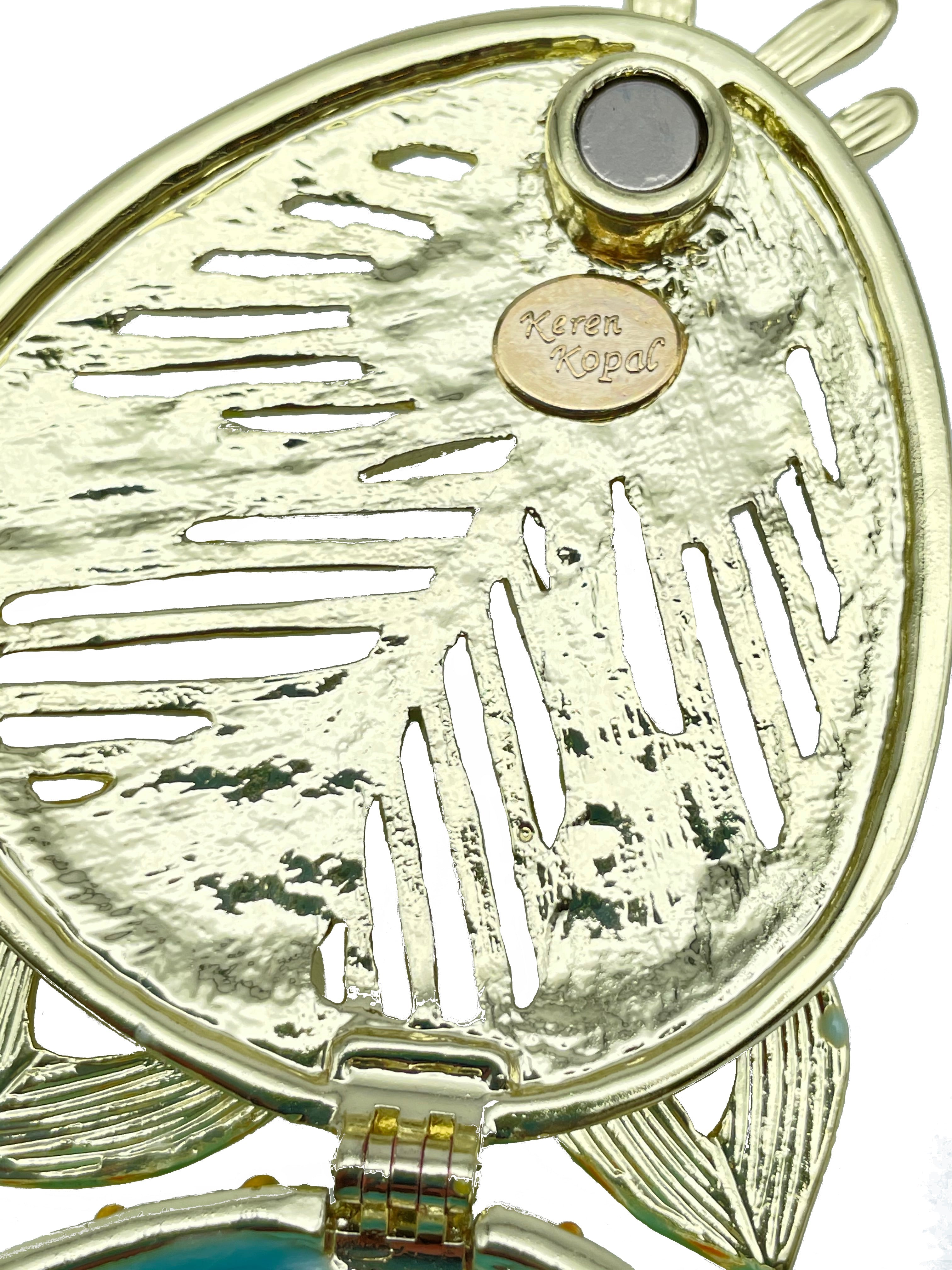 Gold locket with leaf design and 'Keren Kopal' branding on a white background