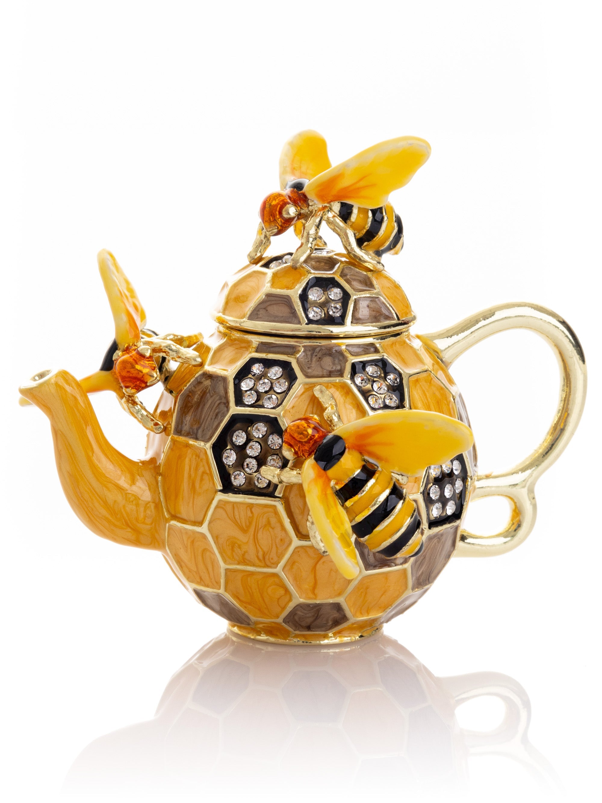 Decorative teapot with honeycomb design and bee embellishments on a white background