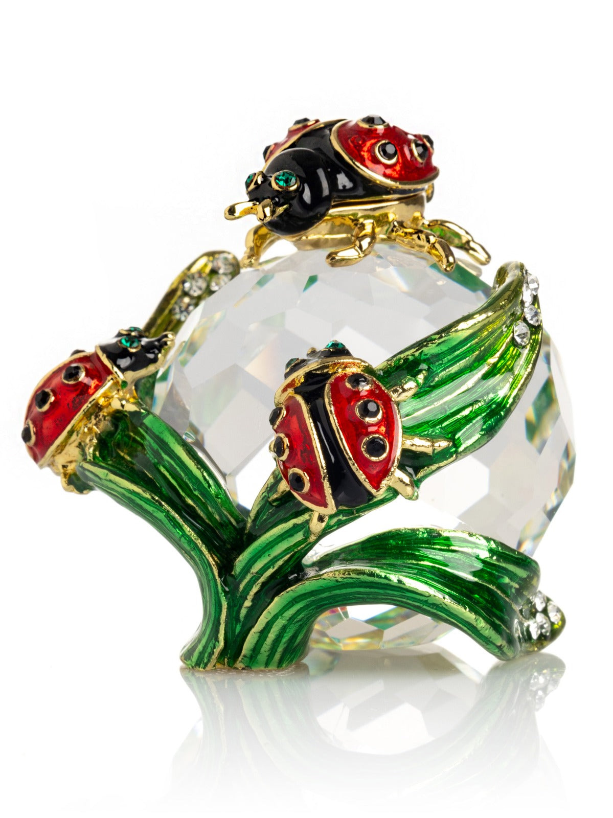 Decorative crystal object with ladybug designs on a white background